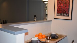 A modern kitchen with a counter displaying oranges and bowls, a decorative lamp, and a framed artwork on the wall. - Large apartment with 2 bedrooms and two bathrooms in PALAZZO SAN MATTEO (Palermo)