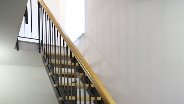 A staircase with wooden steps and black railings, leading to an upper floor. - Casa Gabbiano B (Cefalù)