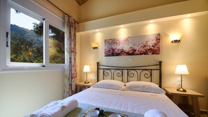 A neatly made bed with a tray of breakfast items, two bedside lamps, and a painting on the wall.