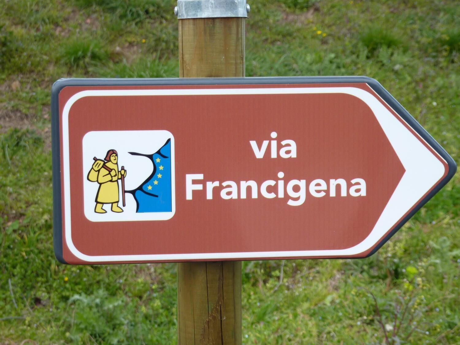 Un panneau de signalisation indiquant une direction, avec une illustration et du texte.