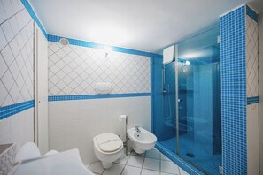 A bathroom with a toilet, bidet, and glass-enclosed shower. - Villa La Baika by MyVillaCollection (Capri)
