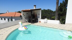 Une piscine avec un flotteur en forme de licorne et un ballon vert.