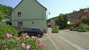 A two-story building with a flat roof and a car parked in front.