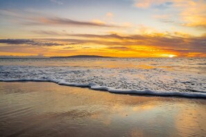 A beach with waves at sunset. - Experience paradise in our cozy 2 bedroom condo near the beach (Kihei)