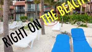 Une vue sur la plage, avec des chaises longues et des palmiers.