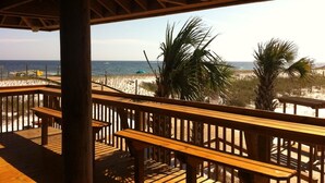 A wooden deck with a view of the beach and palm trees. - One of SPC's most booked units! Poolfront! Brand NEW renovation!  (Destin)