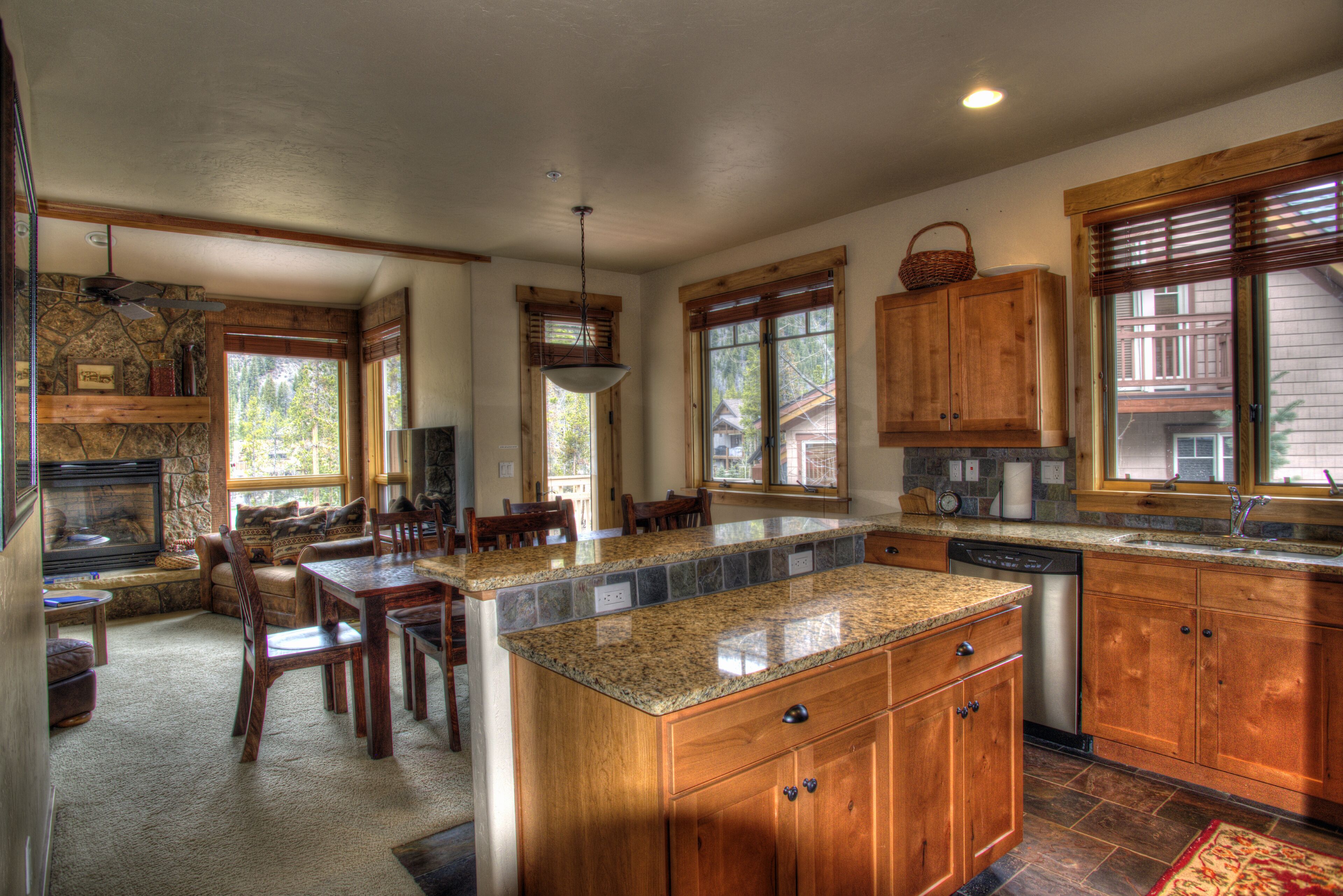 A spacious kitchen with granite countertops, wooden cabinets, and a large island.