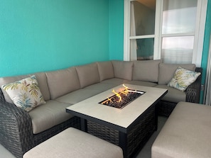 A corner seating area with a built-in fire feature, a cushioned sofa, and a small table.