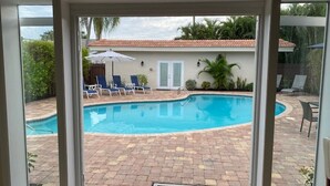 A view of a swimming pool with lounge chairs and a patio area. -  Closest To Beach Main House & Separate Villa 4 Bdrm , Huge Pool. Walk To Beach (Naples)