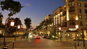 A multi-story hotel with a modern design, featuring balconies and a well-lit facade. -  Closest To Beach Main House & Separate Villa 4 Bdrm , Huge Pool. Walk To Beach (Naples)