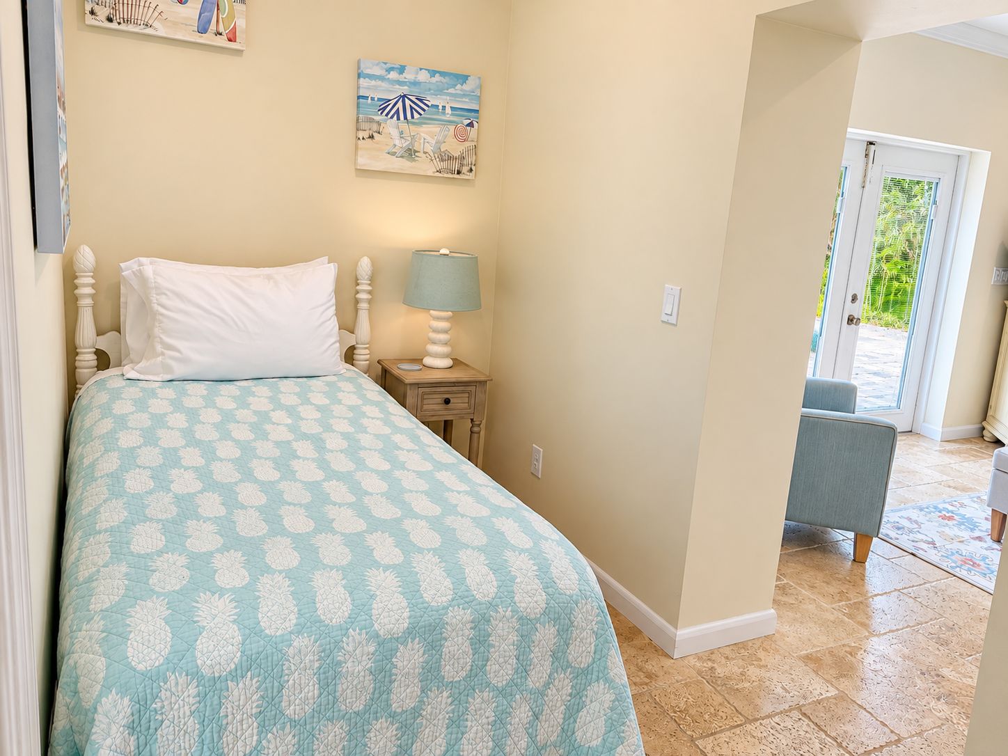 A bedroom with a bed, a nightstand, a lamp, and a painting on the wall.