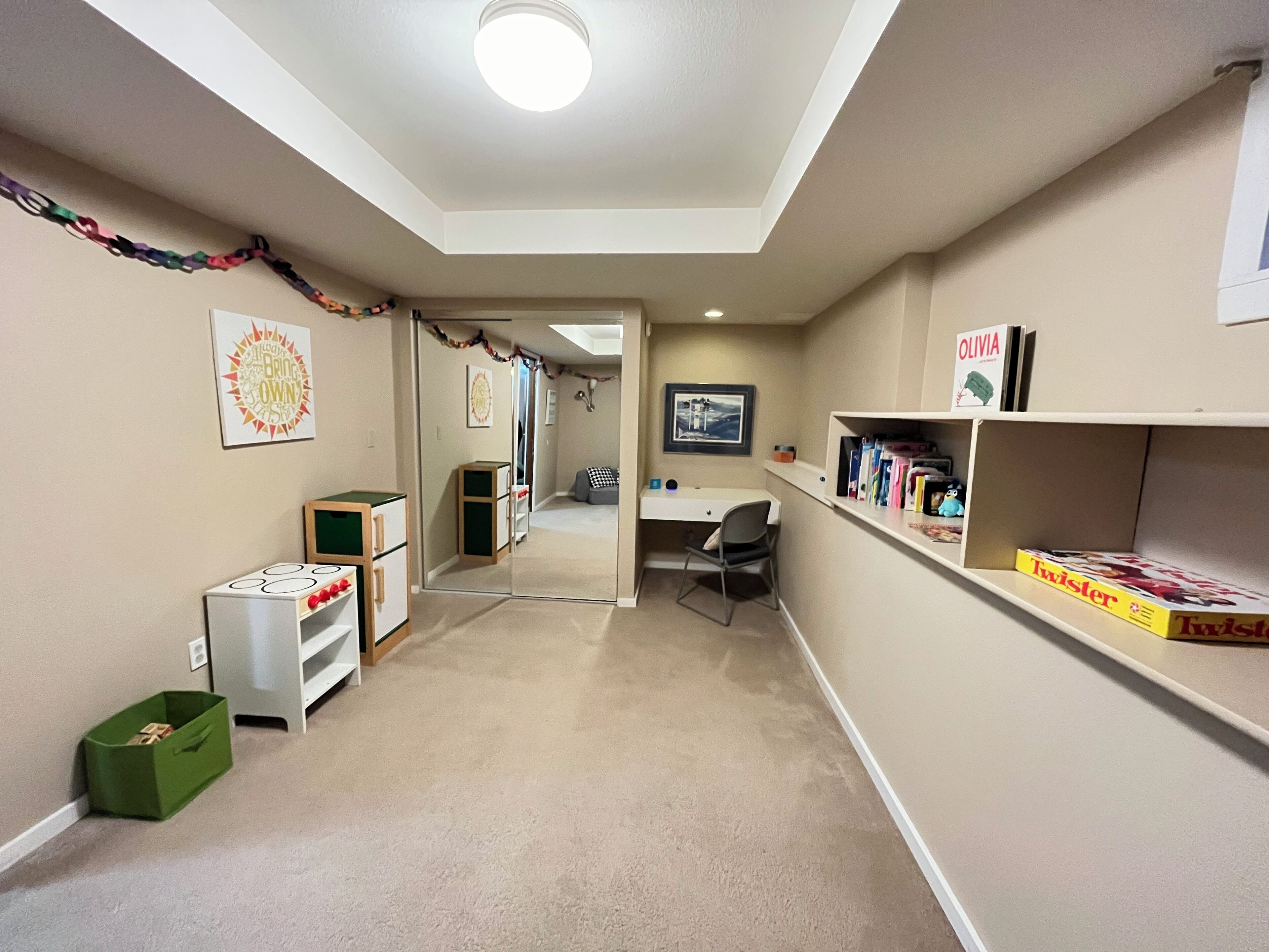 A hallway with a desk, chair, and bookshelves.
