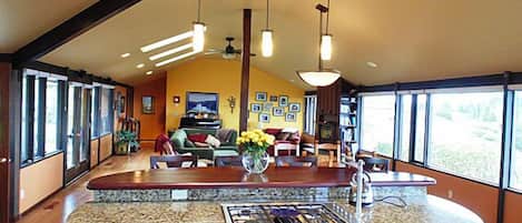 A spacious kitchen with a large island, wooden cabinets, and a granite countertop.