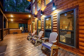 Relax on the covered deck with Adirondack chairs and a hot tub.