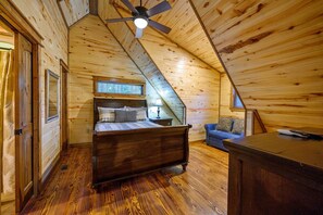 Cozy bedroom with a bed, nightstand, and sofa, offering a comfortable seating area.