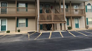 Ein mehrgeschossiges Hotel mit überdachter Eingangspartie und Parkplatz.