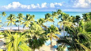 A beach with palm trees and a clear view of the ocean. - Exclusive Oceanfront Corner Penthouse Villa in Amazing Marbella Club!! (Humacao)