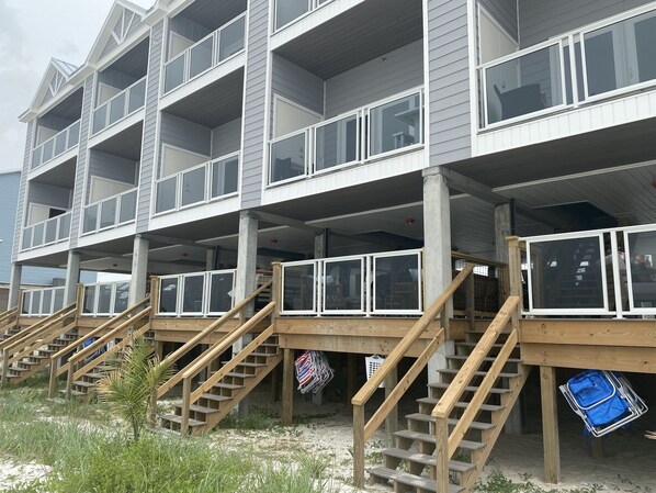 A multi-story building with balconies and wooden staircases leading to the upper floors.