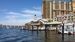 A waterfront hotel with multiple balconies, a pier, and boats.
