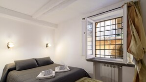 Ein Hotelzimmer mit einem Bett, zwei Wandleuchten, einem Fenster mit Blick und einer Heizung.