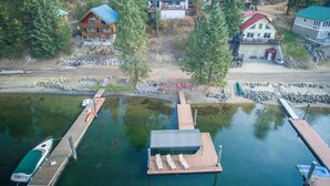 Una propiedad junto al lago con un muelle, un bote y varias casas.