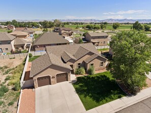 A residential area with houses featuring sloped roofs and a well-maintained lawn. - Velo III: BBQ, Fire Pit & Dog-Friendly Retreat (Fruita)
