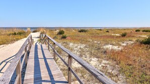 A wooden boardwalk leading to a beach with sand dunes and sparse vegetation. - Large Deck with Awesome Ocean & Marsh View! Free WiFi! Free Hunting Island pass! (St. Helena Island)