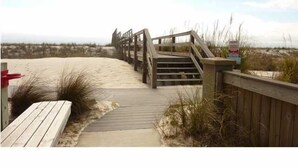 A wooden boardwalk leading to a beach with a staircase and a sign. - White Sandy Beaches, Gulf Front Complex, Heated Pool, Private Patio (Navarre)
