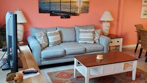 A living room with a sofa, coffee table, and decorative pillows. - White Sandy Beaches, Gulf Front Complex, Heated Pool, Private Patio (Navarre)
