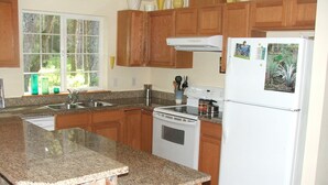 A kitchen with granite countertops, wooden cabinets, a white stove, and a refrigerator with magnets. - Rare Strait of Juan de Fuca no-bank water front, near mouth of Elwha River. (port angeles)