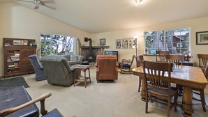 A spacious living room with a fireplace, comfortable seating, and large windows offering views of the outdoors. - Rare Strait of Juan de Fuca no-bank water front, near mouth of Elwha River. (port angeles)