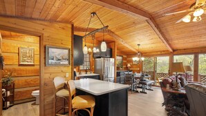 Ein geräumiges Blockhaus-Interieur mit einer großen Küche, einem Essbereich und einer gemütlichen Sitzecke.