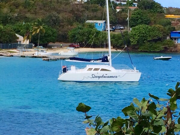 A white yacht named 'Daydreamer' docked at a marina with clear blue water, surrounded by greenery and a few buildings in the background. - Amazing Waterfront Escape: Balcony, Renovated, Paradise At A Great Price! (Saint Thomas)