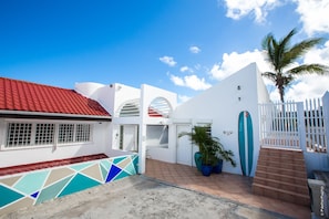 Cottage entrance is door on surfboard wall, glass block door is the front door