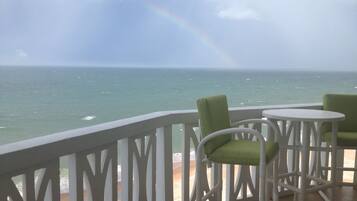 Enjoy the ocean view from this balcony with a comfortable seating area.