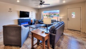 A living room with a fireplace, a sofa, a coffee table, and a television.
