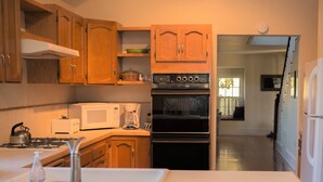 A kitchen with wooden cabinets, a microwave, a coffee maker, and an oven. - Spacious Sebastopol Home — 5-Minute Walk to Town, Wine Country at Your Doorstep (Sebastopol)