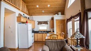 Eine gemütliche Küche mit Holzausstattung, einem weißen Kühlschrank und einem Essbereich mit Tisch und Stühlen.