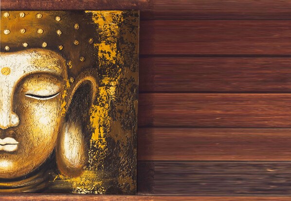 Eine Holzwand mit einer großen, goldfarbenen Buddha-Statue.
