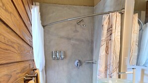 Une salle de bain avec une douche, un lavabo et un miroir.