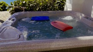 Ein Whirlpool mit Meerblick und einer Pflanze daneben.