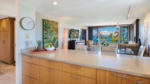 Una cocina moderna con una isla grande, armarios de madera y un reloj en la pared.