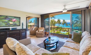 Relax in this inviting living area with a flat-screen TV, comfortable sofa set, and armchairs.