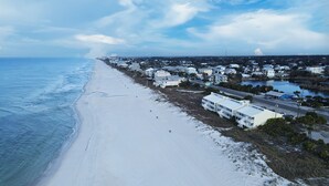 Un pueblo costero con playa, edificios y una carretera.