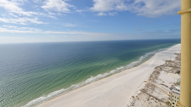 Ein Strand mit freiem Blick auf den Ozean und einem Gebäude auf der rechten Seite.