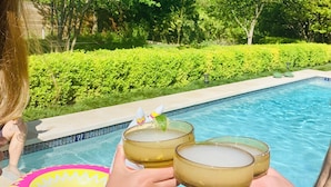 A poolside setting with a clear view of the pool and surrounding greenery. - Historic Luxury Estate - Heated Pool, Hot Tub, Fire Pit & Pool Table for 13 (Fredericksburg)