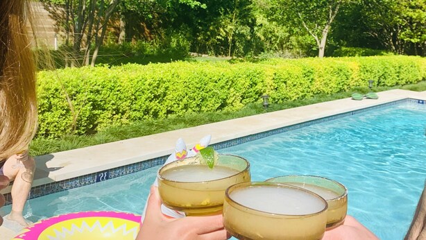 Un espace aménagé au bord de la piscine, offrant une vue dégagée sur la piscine et la végétation environnante.