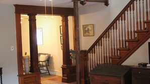 A wooden staircase with a handrail and a dark landing area.