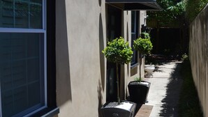A residential building with a number sign, potted plants, and a covered walkway.
