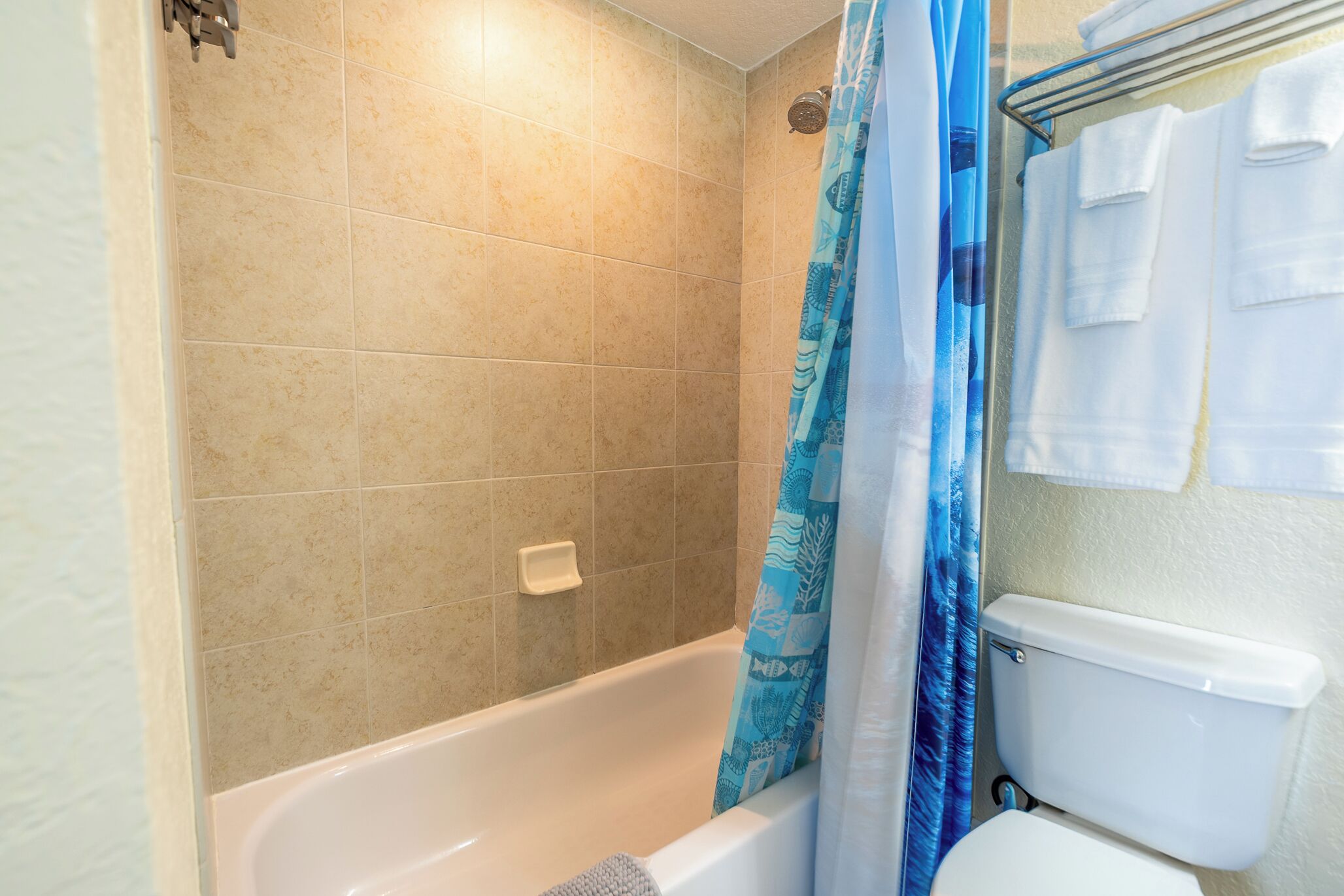 Ein Badezimmer mit Badewanne, Duschvorhang und Toilette.